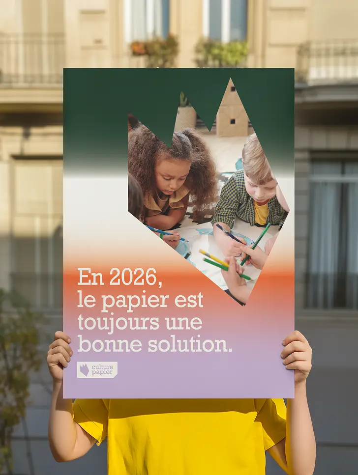 Enfant tenant une affiche avec écrit En 2026 le papier est toujours une bonne solution